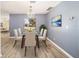 Bright dining room featuring modern chandelier, laminate flooring, and glass-top dining table at 5238 Ne 1St Ave, Ocala, FL 34479