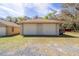 Two-car garage with neutral walls and matching doors located on well-maintained property with gravel and grass surroundings at 5238 Ne 1St Ave, Ocala, FL 34479