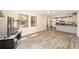 Open-concept living room with sleek wood flooring, filled with natural light, flowing into the kitchen at 5238 Ne 1St Ave, Ocala, FL 34479