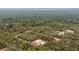 An aerial view shows the home nestled among lush trees on a sprawling lot at 24009 Sw Huckleberry Ln, Dunnellon, FL 34431