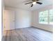 Bedroom with wood-style flooring, a ceiling fan, and a window view, with a door to the side at 24009 Sw Huckleberry Ln, Dunnellon, FL 34431