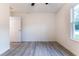 Bright bedroom with hardwood-style floors, a ceiling fan, and a window with views of the outdoors at 24009 Sw Huckleberry Ln, Dunnellon, FL 34431