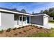 Inviting one story home featuring a blue front door, fresh landscaping, and an attached one car garage at 24009 Sw Huckleberry Ln, Dunnellon, FL 34431