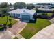 Aerial view of a home with a manicured front yard, long driveway, and neighborhood surroundings at 8400 Mattituck Cir, Orlando, FL 32829