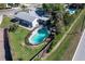 Aerial view of fenced backyard, pool, fire pit and home, showcasing outdoor living and private setting at 8400 Mattituck Cir, Orlando, FL 32829