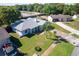 Aerial view of a single-story home featuring a lush green lawn, mature trees, and a spacious driveway at 8400 Mattituck Cir, Orlando, FL 32829