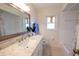 Bathroom featuring a white vanity with a light marble countertop, a decorative mirror and tiled floors at 8400 Mattituck Cir, Orlando, FL 32829