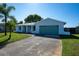 Single-story home with a well-kept front yard, long driveway, blue garage door, and welcoming entrance at 8400 Mattituck Cir, Orlando, FL 32829