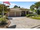 Charming single-story home featuring a paver driveway, tile roof, manicured landscaping, and a two-car garage at 6656 Sw 179Th Court Rd, Dunnellon, FL 34432