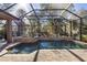 Screened pool area featuring a sun-drenched pool, elegant tile surround, and lush landscaping at 6656 Sw 179Th Court Rd, Dunnellon, FL 34432