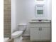 Modern bathroom with gray tiled walls, granite vanity, white sink and cabinetry, and modern fixtures at 18 Malauka Loop Pass, Ocklawaha, FL 32179