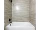 A well-maintained bathtub and shower combination features tile surround and black fixtures at 18 Malauka Loop Pass, Ocklawaha, FL 32179