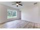Bright bedroom featuring a ceiling fan, window overlooking the yard, and light gray flooring at 18 Malauka Loop Pass, Ocklawaha, FL 32179