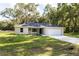 Charming single-story home featuring a two-car garage, well-maintained lawn, and complemented by mature trees at 18 Malauka Loop Pass, Ocklawaha, FL 32179