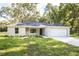 Charming single-story home featuring a two-car garage, well-maintained lawn, and complemented by mature trees at 18 Malauka Loop Pass, Ocklawaha, FL 32179