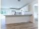 A well-lit kitchen featuring white cabinets, granite countertops and a black faucet over modern wood-look flooring at 18 Malauka Loop Pass, Ocklawaha, FL 32179
