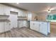 A well-lit kitchen with modern white cabinets and wood-look floors with granite countertops and an island at 18 Malauka Loop Pass, Ocklawaha, FL 32179