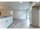 A well-lit open floor plan with the kitchen featuring modern white cabinets and wood-look floors with granite countertops at 18 Malauka Loop Pass, Ocklawaha, FL 32179