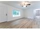 A bright, airy room with modern wood-look floors and view into the bathroom and an exterior window at 18 Malauka Loop Pass, Ocklawaha, FL 32179