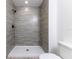 Walk-in shower with tiled walls, gray horizontal tiling, and matte black fixtures at 18 Malauka Loop Pass, Ocklawaha, FL 32179