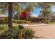 Beautiful clubhouse exterior with red facade, covered entrance, and lush landscaping under a sunny sky at 4410 Sw 52Nd Cir # 108, Ocala, FL 34474