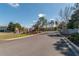 Community entrance with decorative stone signage, manicured landscaping and a well-maintained asphalt road at 4410 Sw 52Nd Cir # 108, Ocala, FL 34474