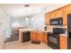 Kitchen featuring stainless steel sink, wooden cabinets, black appliances, and overhead lighting fixtures at 4410 Sw 52Nd Cir # 108, Ocala, FL 34474