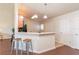 Kitchen and bar with three wooden stools, with dark hardwood floors and modern lighting at 4410 Sw 52Nd Cir # 108, Ocala, FL 34474