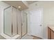 Enclosed glass shower with neutral tiling and an adjacent door for easy access at 4410 Sw 52Nd Cir # 108, Ocala, FL 34474