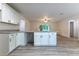Bright kitchen boasts white cabinets, granite countertops, and wood-look flooring at 61 Fisher Way Crse, Ocklawaha, FL 32179
