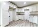 Bright kitchen boasts white cabinets, granite countertops, and wood-look flooring at 61 Fisher Way Crse, Ocklawaha, FL 32179