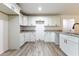 Bright kitchen boasts white cabinets, granite countertops, and wood-look flooring at 61 Fisher Way Crse, Ocklawaha, FL 32179