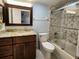 Well-lit bathroom with a granite countertop vanity, toilet, and shower-tub combination with glass door at 3370 Ocean Shore Blvd # 5020, Ormond Beach, FL 32176