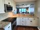 Open kitchen showcasing granite counters, stainless appliances, and a view to the living area and balcony at 3370 Ocean Shore Blvd # 5020, Ormond Beach, FL 32176