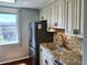 Kitchen featuring stainless refrigerator, sink, granite countertops, tile backsplash, and window views at 3370 Ocean Shore Blvd # 5020, Ormond Beach, FL 32176