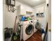 Functional laundry room with white cabinets, modern washer and dryer, and durable wood-look flooring at 3370 Ocean Shore Blvd # 5020, Ormond Beach, FL 32176