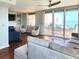 Bright living room featuring hardwood floors, a comfortable sofa, and sliding doors to a balcony with ocean views at 3370 Ocean Shore Blvd # 5020, Ormond Beach, FL 32176