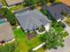 Aerial view of a house with a gray roof, landscaping, manicured lawn and swimming pool at 14867 Bonnybridge Dr, Orlando, FL 32826