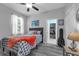 Comfortable bedroom with a ceiling fan, a window, and hardwood floors at 14867 Bonnybridge Dr, Orlando, FL 32826