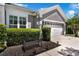 Charming gray home featuring a well-manicured lawn, lush landscaping, and a two-car garage at 14867 Bonnybridge Dr, Orlando, FL 32826