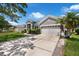 Charming gray home featuring a well-manicured lawn, lush landscaping, and a two-car garage at 14867 Bonnybridge Dr, Orlando, FL 32826