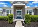 The home's entry features a recessed doorway with bright blue doors, green bushes, and mulch beds at 14867 Bonnybridge Dr, Orlando, FL 32826