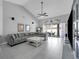 Large living room features a cozy sectional, ceiling fan, and glass sliding doors at 14867 Bonnybridge Dr, Orlando, FL 32826