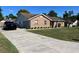 Lovely brick home featuring an attached garage, long driveway, and lush green lawn at 3295 Se 56Th Ave, Ocala, FL 34480