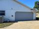The garage with a gray door and concrete driveway offers ample parking and curb appeal at 3295 Se 56Th Ave, Ocala, FL 34480