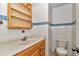 Bathroom featuring tiled walls, a vanity with storage, and a toilet, offering essential amenities at 8082 Sw 103Rd Ln, Ocala, FL 34481