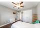 A well-lit bedroom features hardwood floors, a ceiling fan, and a closet for storage at 9945 Sw 55Th Avenue Rd, Ocala, FL 34476