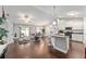 Open-concept living space with hardwood floors, flowing into a modern kitchen with an island and barstools at 9945 Sw 55Th Avenue Rd, Ocala, FL 34476