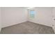 Neutral bedroom with gray carpet, white walls, and window at 6683 Se 3Rd Loop, Ocala, FL 34472
