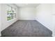 Bright bedroom features a large window and neutral gray carpet at 6683 Se 3Rd Loop, Ocala, FL 34472